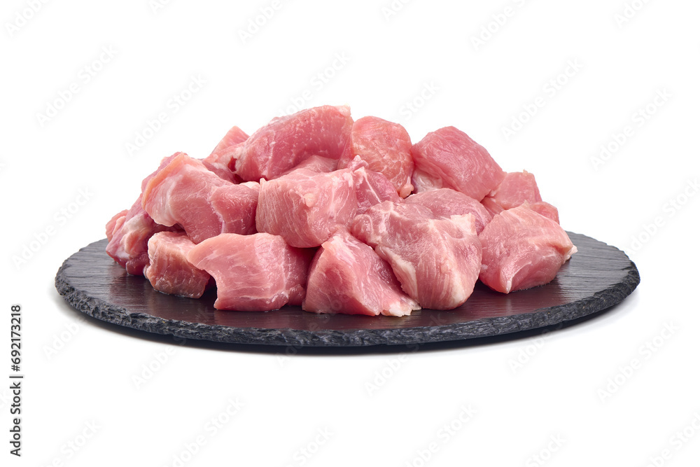 Raw pork pieces on stone plate, close-up, isolated on white background. Raw pork pieces on stone plate, close-up, isolated on white background.