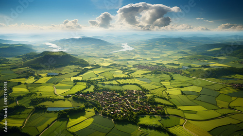 Aerial view of a patchwork of different agricultural fields, illustrating various stages of crop growth, with a small farmhouse in the distance photo