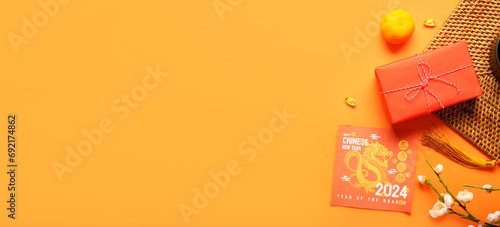 Greeting card, gift and decor on orange background with space for text. Chinese New Year celebration photo
