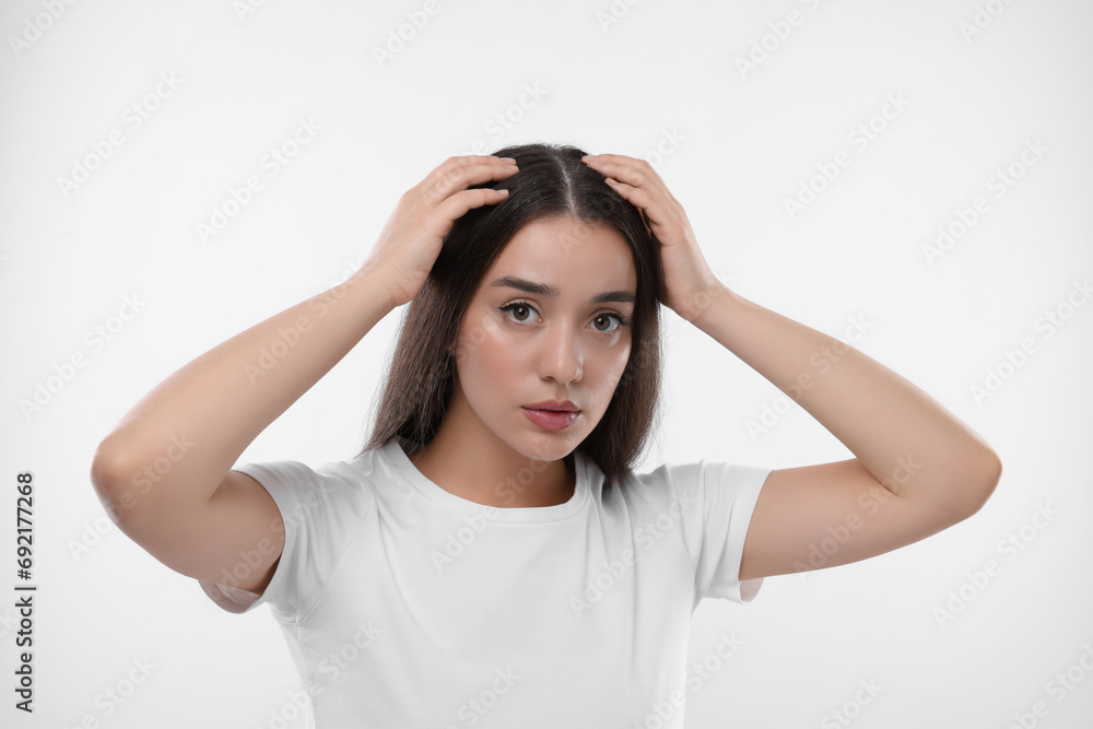Woman suffering from dandruff problem on white background Woman suffering from dandruff problem on white background