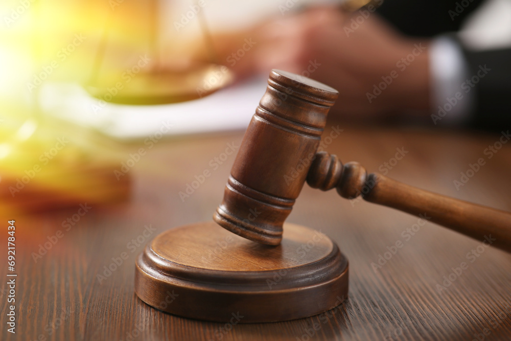 Law and justice. Judge working at wooden table, focus on gavel Law and justice. Judge working at wooden table, focus on gavel