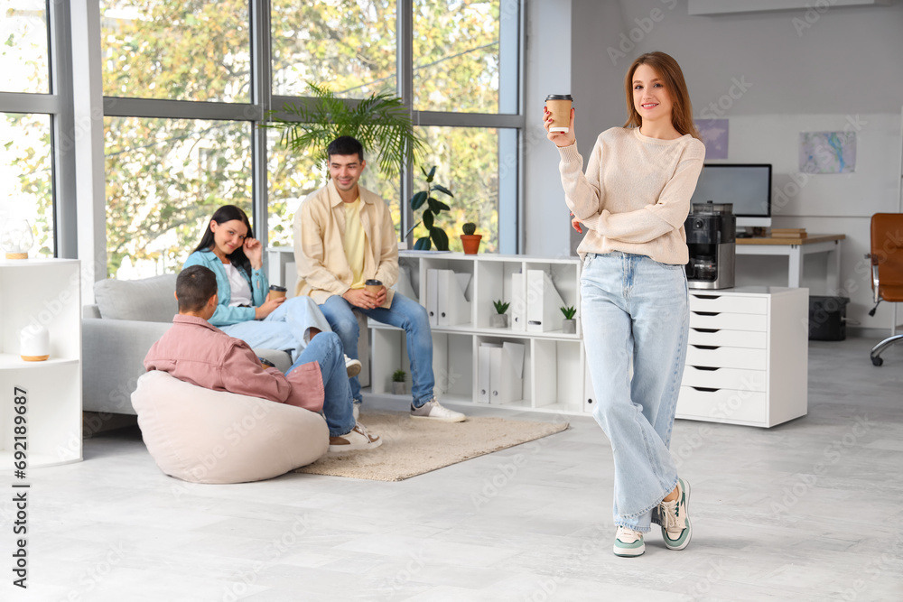 Young woman having coffee break in office