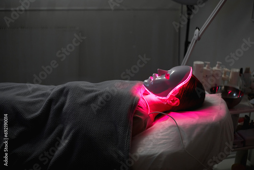 Woman getting cosmetic procedure with LED facial mask. , photon therapy photo