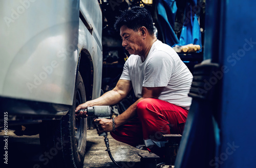 Mechanician changing car wheel in auto repair shop. changing wheels/tires. Concept of car care service and maintenance or fix the car