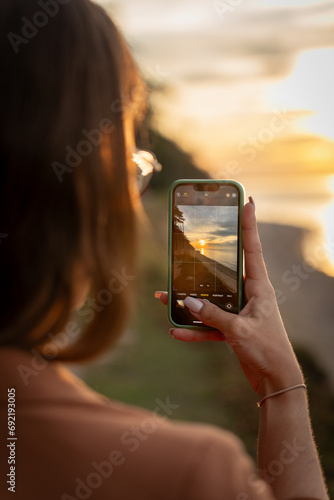 Picture in picture sunset photo of a woman's phone