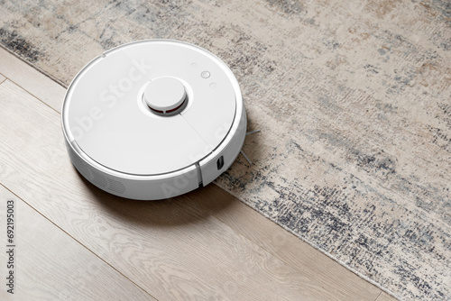 Smart robot vacuum cleaner on the carpet and on the laminate removes dust.