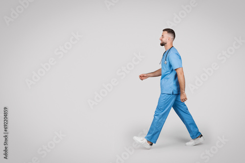 Male nurse walking confidently, wearing blue scrubs