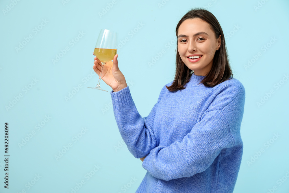 Beautiful young woman with glass of white wine on blue background Beautiful young woman with glass of white wine on blue background