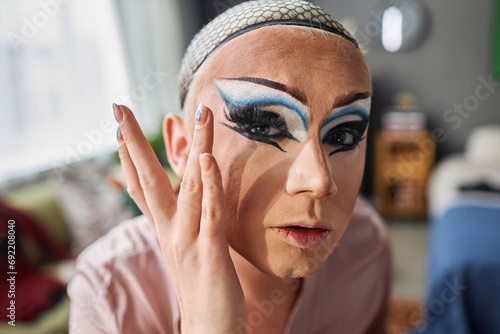 POV of male drag queen performer putting on fake eyelashes and doing makeup preparing for stage photo