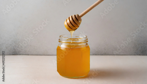 Honey in a glass jar with a wooden spoon dipper