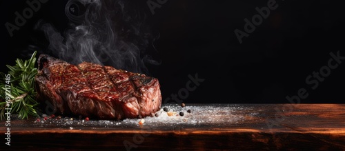 Barbecue dry aged wagyu entrecote beef steak roast with lettuce and salt as closeup on a charred wooden board. Copy space image. Place for adding text or design photo