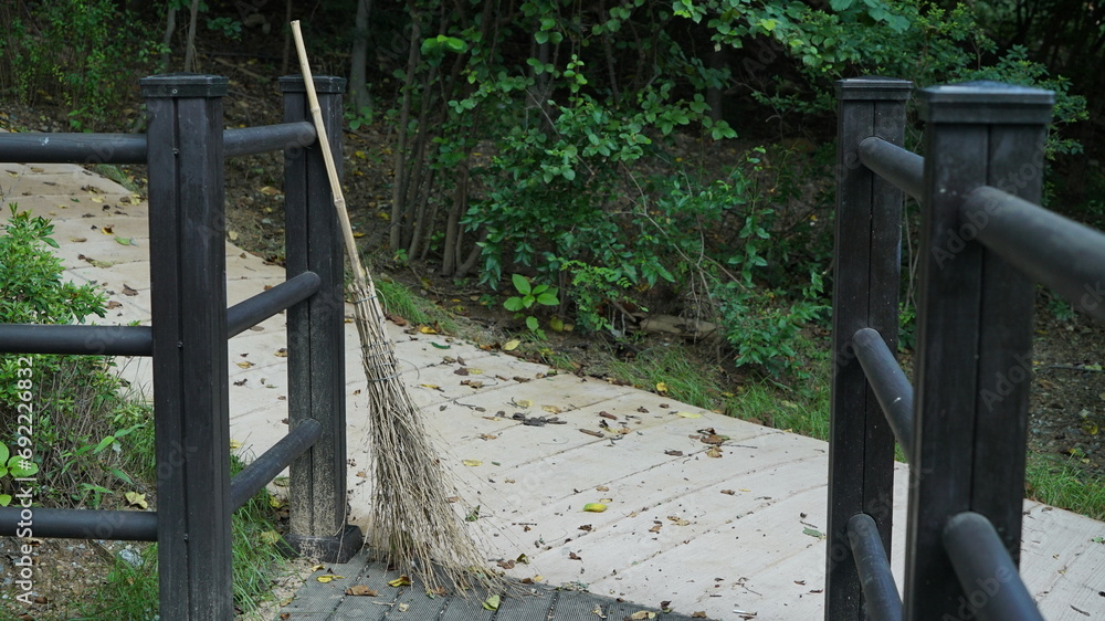 Standing Broom Stick on a walking path in an outdoor park Standing Broom Stick on a walking path in an outdoor park
