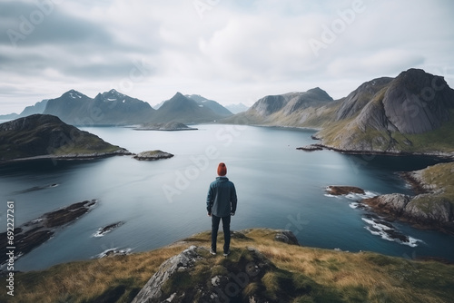 Shot of young man hiker stands on top of mountain after long difficult hike in Norway daylight