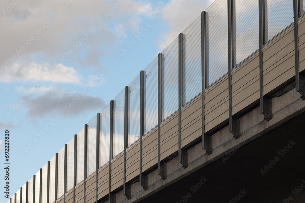 Fototapeta premium noise insulating transparent shields on the freeway in the background blue sky and clouds