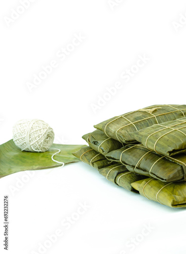 Venezuelan hallacas or hayacas wrapped in banana leaves with a roll of wick or pabilo with a white background. Traditional Venezuelan Christmas dish. Typical recipe for Christmas dinner. photo