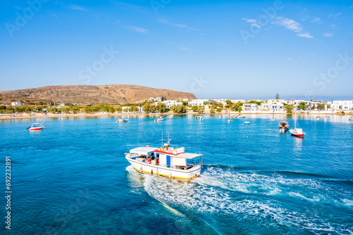 View of boat on sea and Pollonia port houses from deck ferry from Kimolos, Milos island, Cyclades, Greece photo