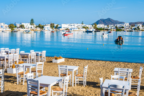 Taverrna chairs and tables on beach in Pollonia port, Milos island, Cyclades, Greece