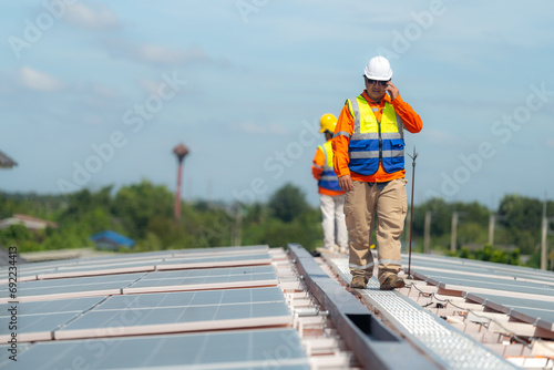 Engineer man is working to construct solar panels system on roof. Installing solar photovoltaic panel system. Alternative energy ecological concept. Renewable clean energy technology concept.