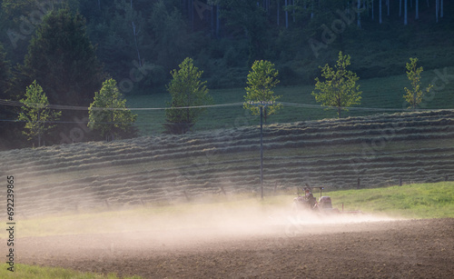 Staubwolke beim Eggen eines Ackers