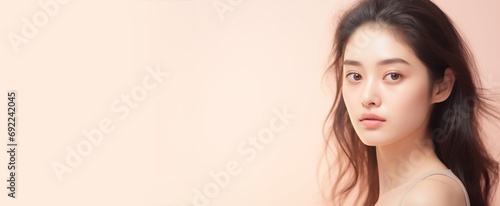 Young Japanese woman looking off into the distance, skin care product concept, space for text photo