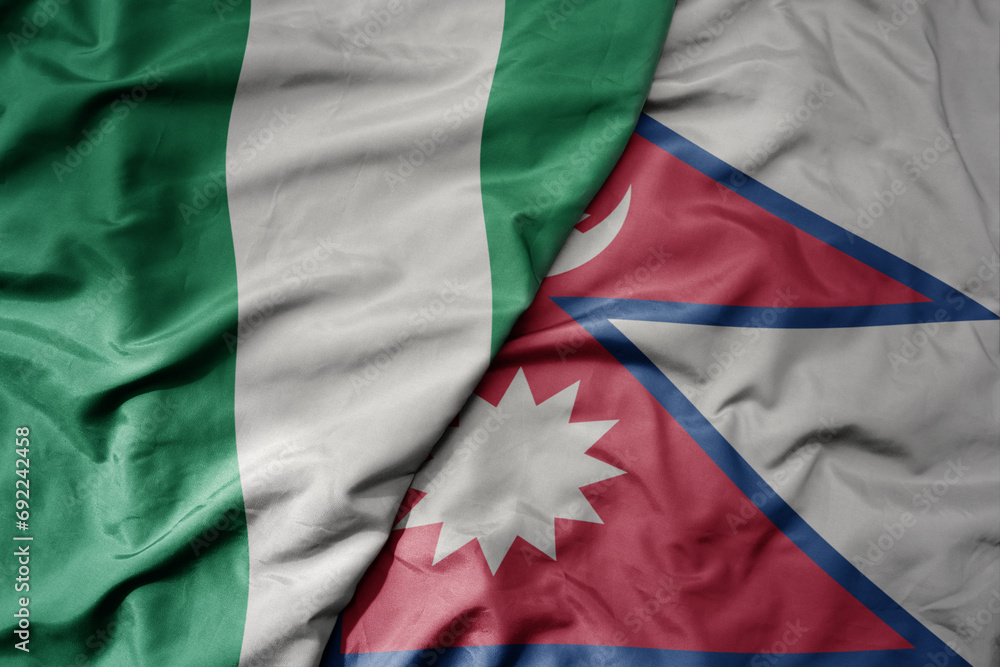 Obraz premium big waving national colorful flag of nepal and national flag of nigeria .