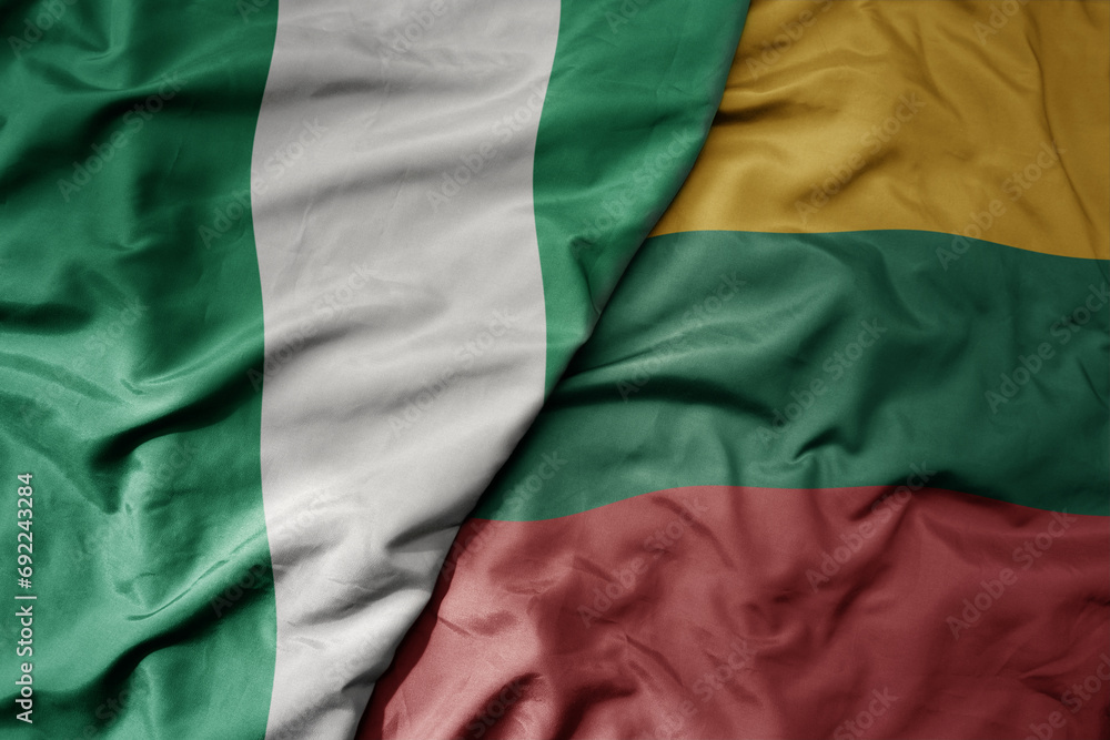 big waving national colorful flag of lithuania and national flag of nigeria . big waving national colorful flag of lithuania and national flag of nigeria .