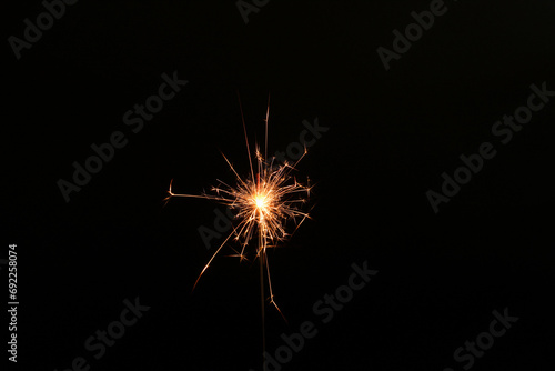 Burning sparkler stick on black background  space for text