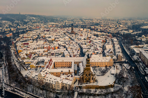 Panorama Luftbildaufnahme von Amberg in Bayern bei Sonnenuntergang im Winter mit schneebedeckten Dächern