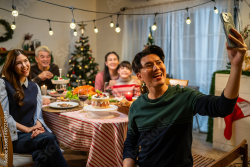Asian family taking a photo while celebrate christmas party together. 
