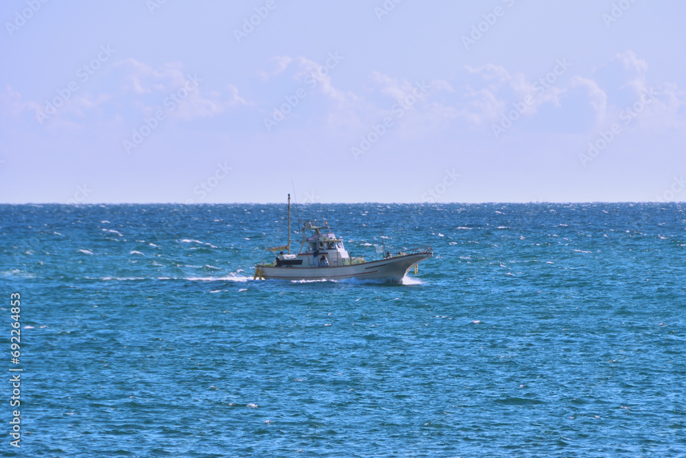 青い海を疾走する漁船