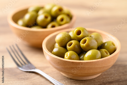 Bilde på lerret Pickled olives, Pitted green olives in wooden bowl