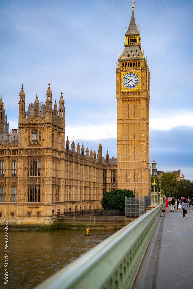 Obraz premium Amazing view of majestic historic palace and historical buildings near Big Ben against clock tower on cloudy day in London