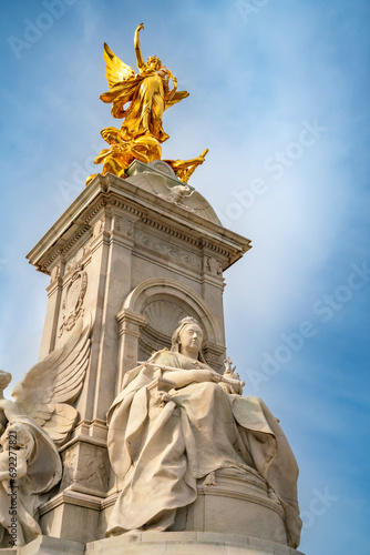 From below of Queen Victoria Memorial monument located at the end of The Mall in front of The Buckingham Palace under cloudy blue sky in Westminster, London photo