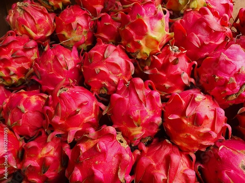 Close up pile of tasty fresh dragon fruits sold at the market as a background.