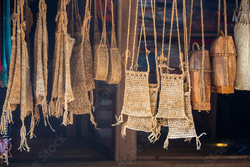 various items are hung made from rattan, leather and thread to form bags, totes and various variations that are ready to be sold photo