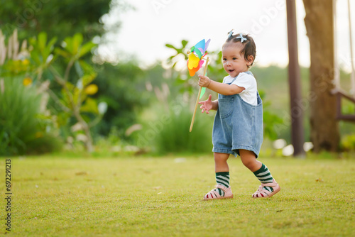 infant baby playing and walking first step on green grass in park photo