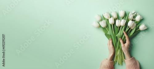 Beautiful white tulip in the hand of woman on green background, generative ai #692295207