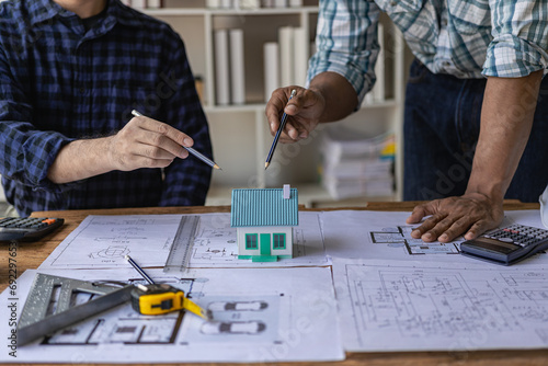 Group of engineers and working meeting and discussing construction planning with blueprints with architect equipment. Architects talking at table, teamwork and work flow construction concept.