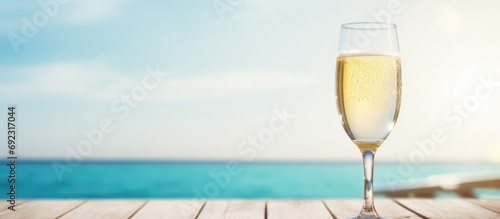Sparkling champagne or prosecco on a white wooden table by the pool in summer.