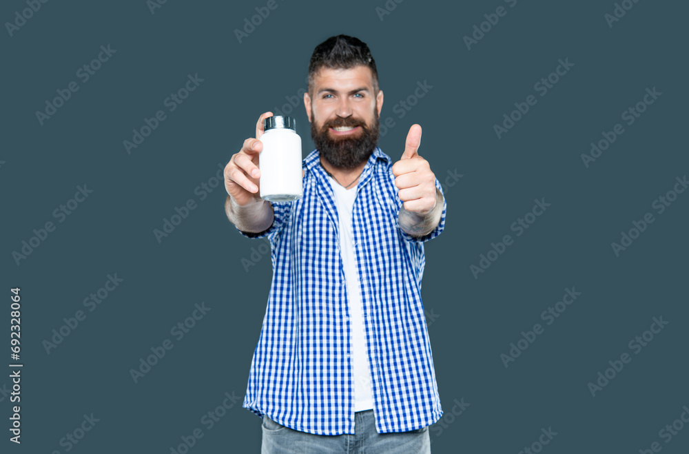selective focus of mature man hold medication jar on grey background selective focus of mature man hold medication jar on grey background