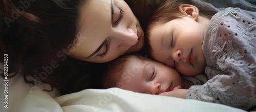 Mother cuddles her infant in bed. Nine-month-old. Parental affection and nurturing. photo
