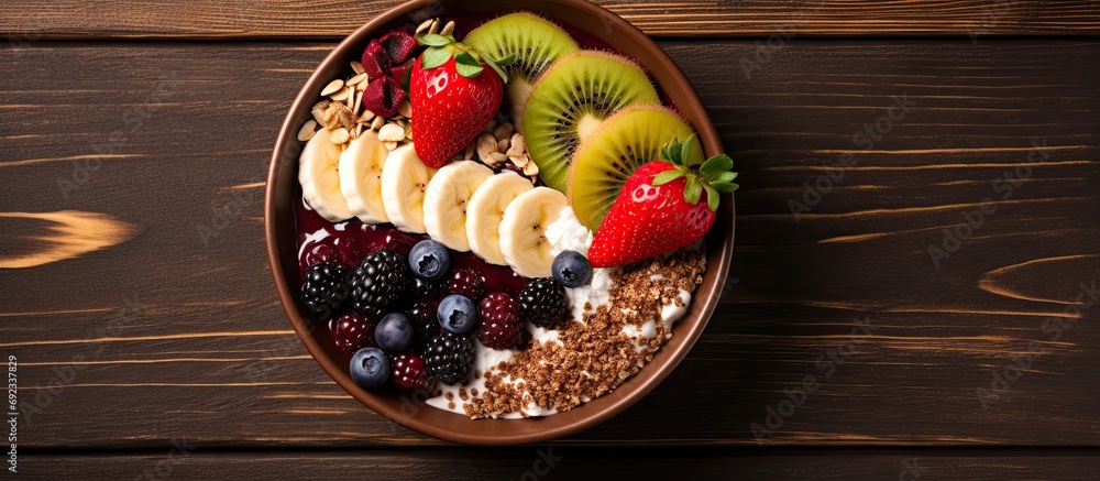 An acai breakfast bowl with various superfood toppings and fruits, viewed from above with space for text. An acai breakfast bowl with various superfood toppings and fruits, viewed from above with space for text.