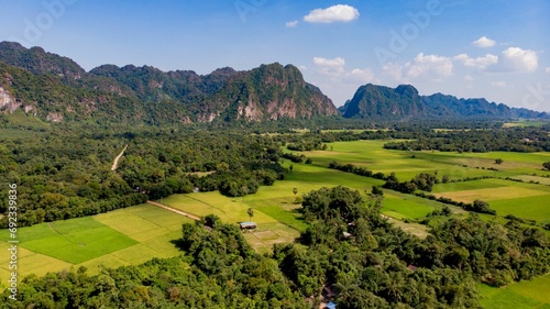 Aerial view of lush green fields surrounded by towering mountains in Myanmar photo
