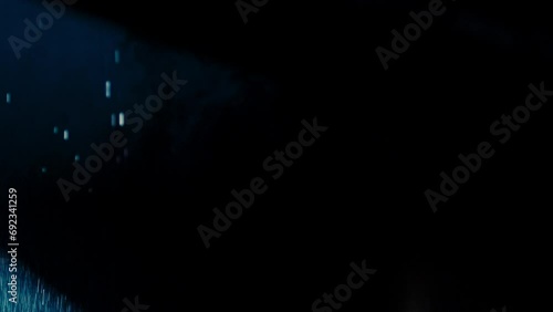 Abstract dark background with blue cold flashing light beam spot and laser illuminate falling rain and smoke. Wide beams in the foreground and glashing narrow beams in background.