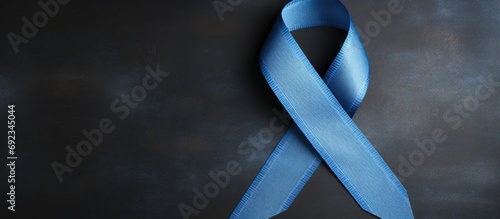 Blue ribbon signifies November campaign for prostate cancer awareness and men's health on denim jeans. photo