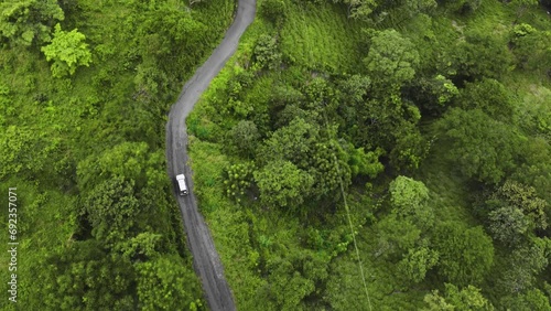 aerial of 4x4 jeep touring car driving off road crossing jungle green deep vegetation exploring Costa Rica  photo