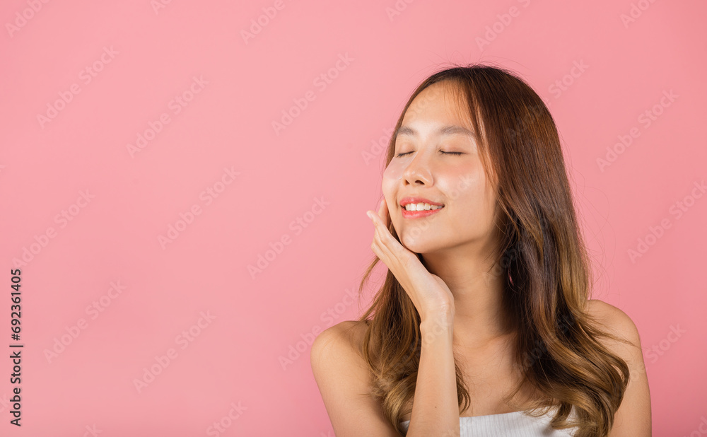 Anti aging. Asian beautiful young woman smiling mask cosmetic patches gel under the eyes, Portrait female applying medical hydrogel eye patch on face, studio shot isolated on pink background, skincare Anti aging. Asian beautiful young woman smiling mask cosmetic patches gel under the eyes, Portrait female applying medical hydrogel eye patch on face, studio shot isolated on pink background, skincare