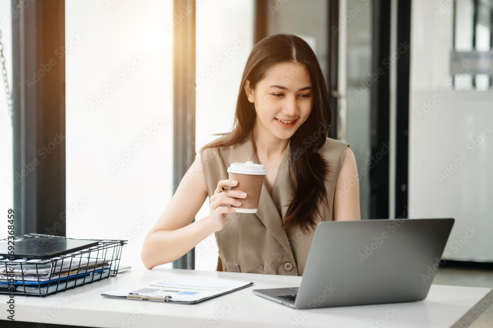 Young beautiful woman using laptop and tablet while sitting at her working place. Concentrated at work. Young beautiful woman using laptop and tablet while sitting at her working place. Concentrated at work.
