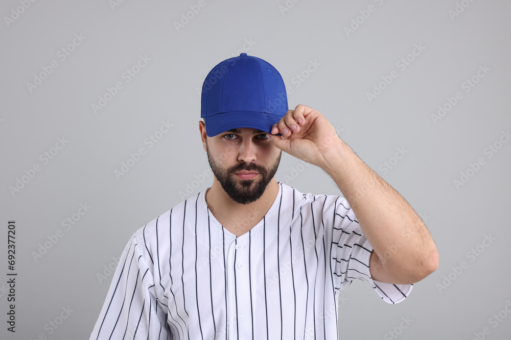 Man in stylish blue baseball cap on light grey background