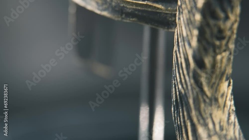 A close up macro detailed tilt down shot of a spartan face design, warrior metal bronze helmet, on a 360 rotating stand, studio lighting, 4K smooth movement photo